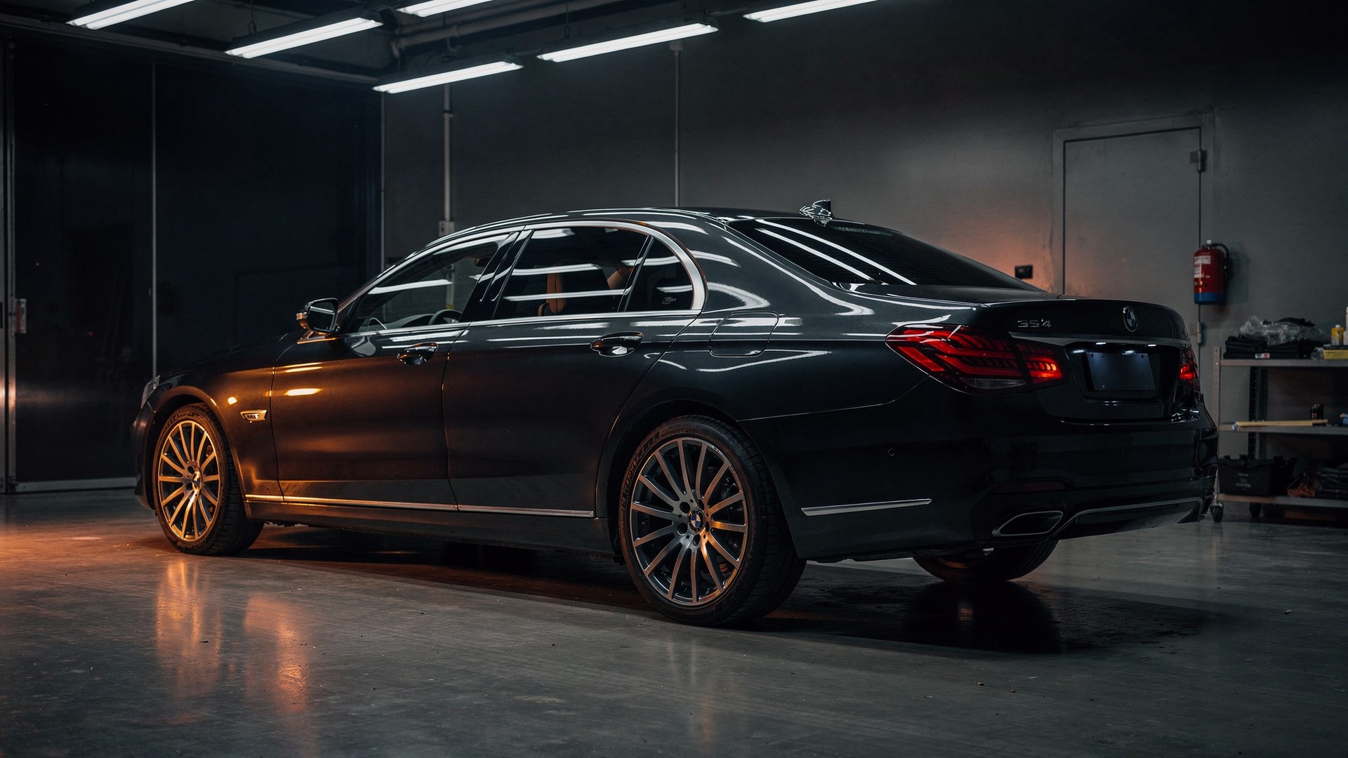Sedan negru în hala de detailing, sub lumini reci